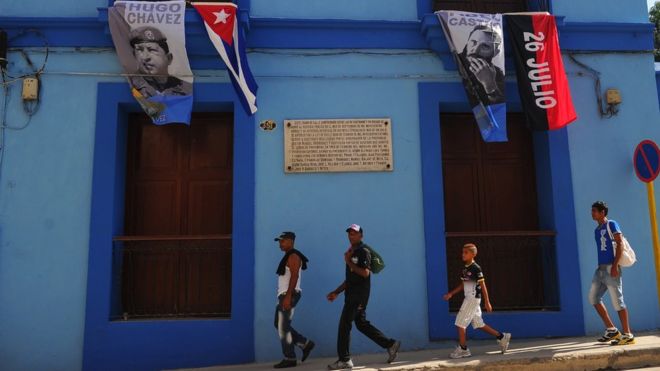 Флаги с изображениями бывшего президента Кубы Фиделя Кастро (справа) и покойного президента Венесуэлы Уго Чавеса видны в Сантьяго-де-Куба 25 июля 2015 года