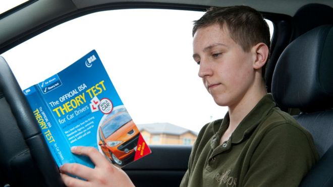 Подросток изучает официальный тест теории для водителей автомобилей