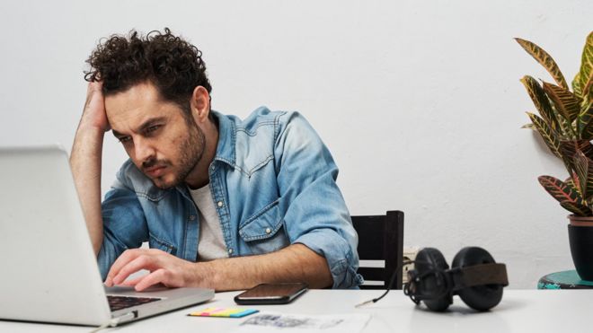 Un hombre trabajando frente al computador.