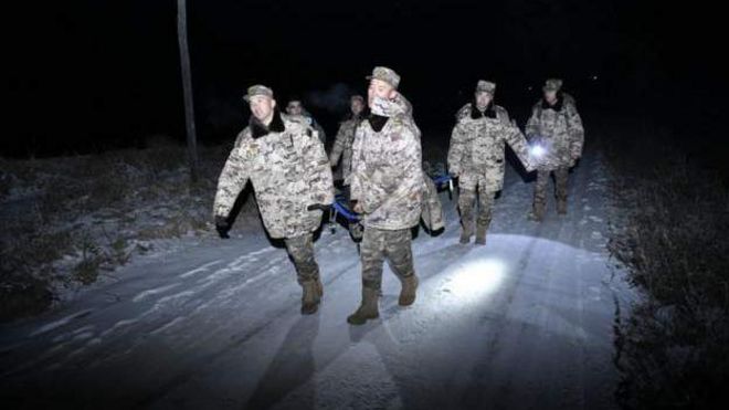 भारी ठंड में बचावकर्मी घायल शख़्स को ले जाते हुए