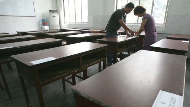 Учителя наклеивают номера кандидатов на парты в экзаменационной комнате за день до вступительного экзамена в Национальный колледж 6 июня 2007 года в Сиане провинции Шэньси
