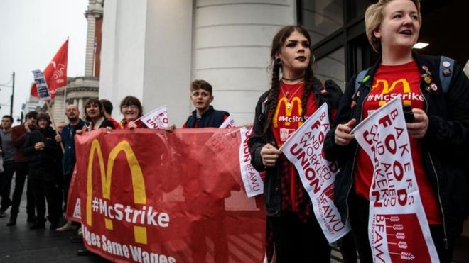 Демонстранты протестуют возле ресторана McDonald's в Брикстоне в поддержку бастующих работников фаст-фуда
