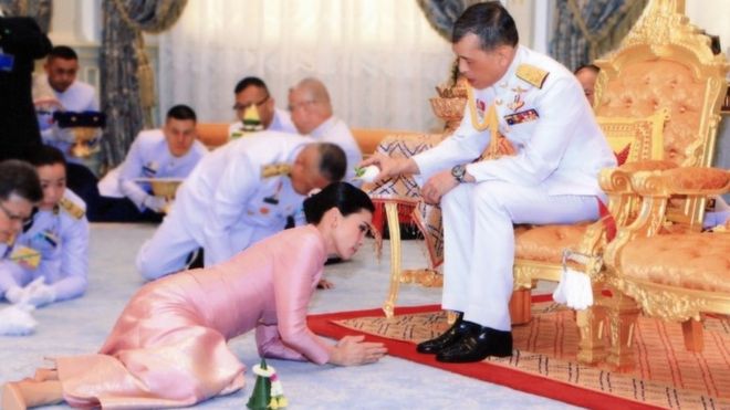 Raja terlihat menuangkan air suci di kepala Ratu Suthida.
