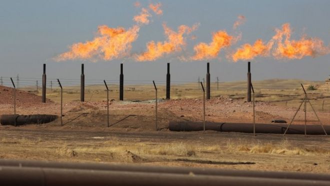 Избыточные легковоспламеняющиеся газы горят от газовых факелов на месторождении Бай Хасан, к западу от многоэтнического северного иракского города Киркук (17 октября 2017 года)