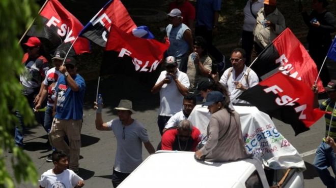 Сторонники президента Никарагуа Даниэля Ортега держат флаги Сандинистского фронта национального освобождения (ФСЛН) на марше в Манагуа, Никарагуа, 28 июля 2018 года.