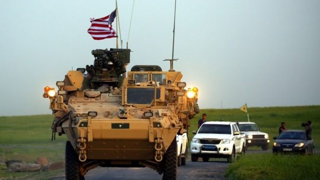 صورة أرشيفية (مركبة تحمل العلم الأمريكي) بمرافقة مقاتلي وحدات حماية الشعب الكردي على الحدود مع تركيا.