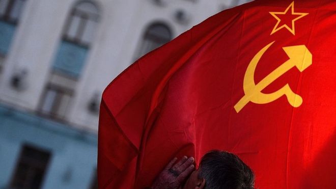 Мужчина целует флаг Советского Союза