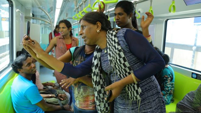 Funcionários transexuais tiram selfies dentro de um dos novos ônibus do metrô de Cochin
