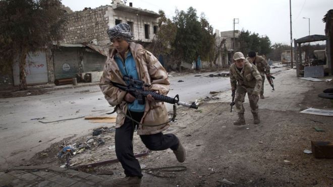 Сирийские туркменские повстанцы пересекают улицу, контролируемую силами режима, чтобы увернуться от снайперского огня в районе Ханано в северном городе Алеппо в 2013 году