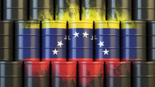 Bandera de Venezuela y barriles de petróleo.