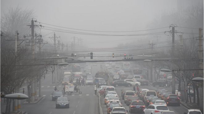Машины проезжают под покровом смога в сильно загрязненный день в Пекине 26 декабря 2015 г.