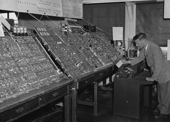 Человек, использующий массивный компьютер в 1956 году