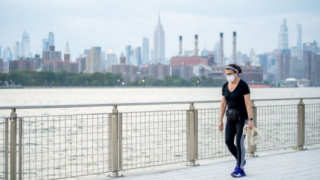 A woman wearing a mask walks through Brooklyn