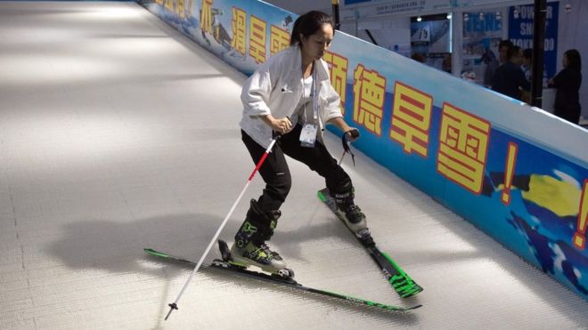 Молодая женщина учится кататься на лыжах в Китае
