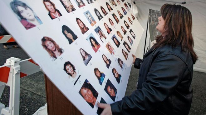 Судебный чиновник Кэтрин Куон развешивает плакат о пропавших женщинах перед судом, где проходит судебный процесс по обвиняемому серийному убийце Роберту Пиктону, 2007