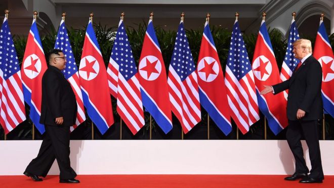 Президент США Дональд Трамп (справа) и лидер Северной Кореи Ким Чен Ун (слева) идут навстречу друг другу в начале своего исторического саммита США-Северная Корея, в отеле Capella на острове Сентоза в Сингапуре 12 июня 2018 года.