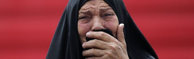 Иракская женщина скорбит на месте взрыва смертельной бомбы в машине-самоубийце в Багдаде 9 июня