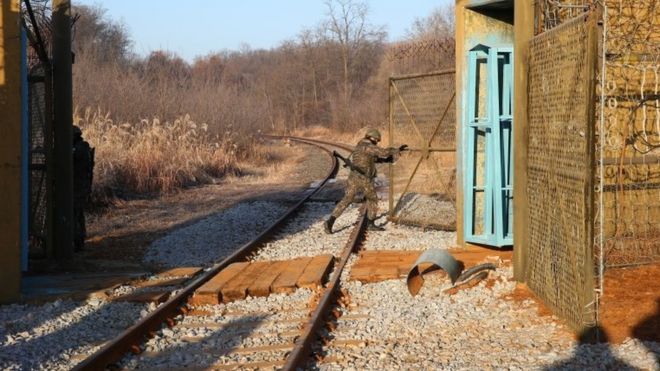 Солдат открывает пограничные ворота внутри ДМЗ между Кореями (30 ноября 2018 года)