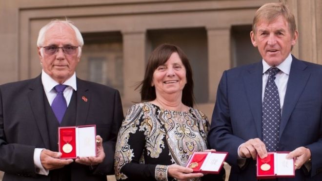 Тревор Хикс, Маргарет Аспиналл и Кенни Далглиш позируют с медалями «Свобода города Ливерпуля» возле Зала Святого Георгия