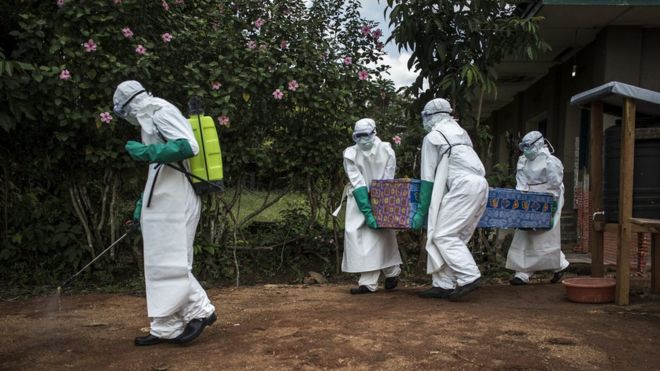 Медицинские работники проводят труп неподтвержденного случая Эболы из центра лечения лихорадки Эбола в Манджине, ДРК