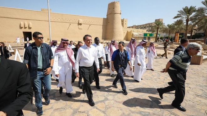 Bolsonaro em visita ao forte Masmak, em Riade, rodeado por representantes do governo saudita e assessores