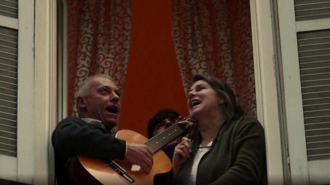 Pessoas cantando de janelas na Itália