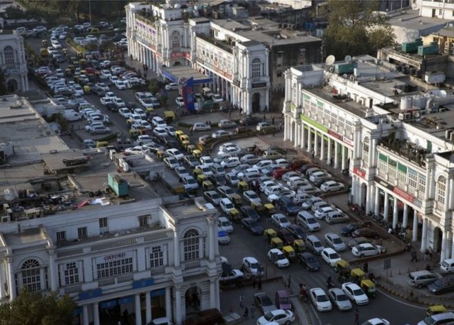 Автомобили и авторикши проезжают через центральную площадь Коннот-Плейс в Нью-Дели, Индия, четверг, 24 декабря 2015 года.