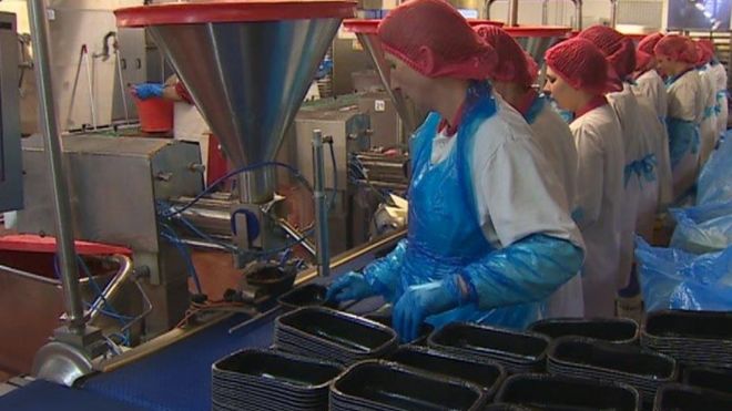 Фотография работников пищевой промышленности вокруг конвейерной ленты