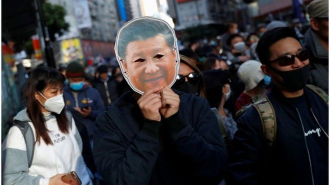 A protester holds a mask depicting China"s President Xi Jinping as he attends a Human Rights Day march, organised by the Civil Human Right Front, in Hong Kong, China December 8,