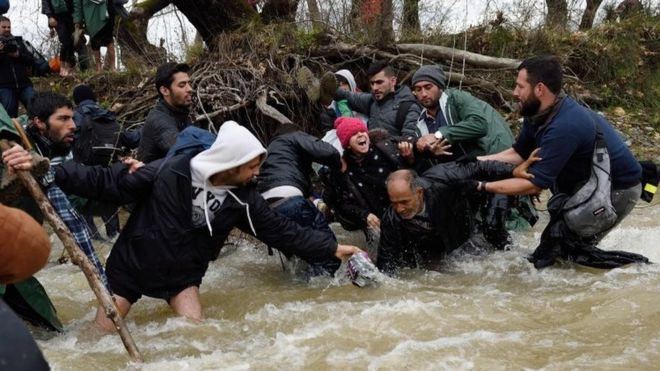 Мигранты падают в реку по пути в Македонию. Фото: 14 марта 2016 г.