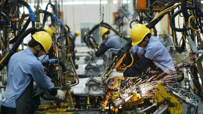 Сотрудники, работающие на автомобильном заводе в Китае
