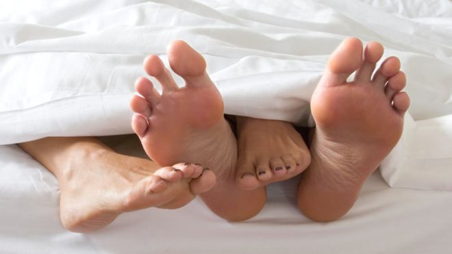 Feet of a couple in bed