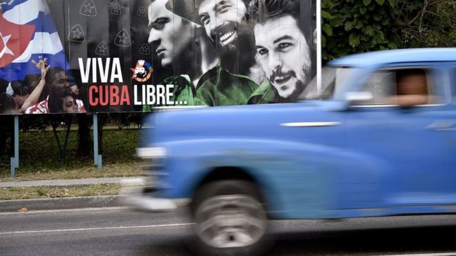 Un auto antiguo transita al lado de un aviso en la plaza de la Revolución en La Habana el 19 de marzo de 2016.