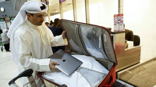 Кувейтский активист социальных сетей Тамер аль-Дахил Бурашед кладет свой ноутбук в свой чемодан в международном аэропорту Кувейта в Кувейте, 23 марта