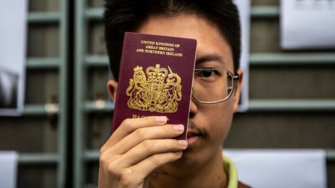 A Petitioner is seen holding up a BNO passport outside the British Consulate in Hong Kong on August 21, 2019