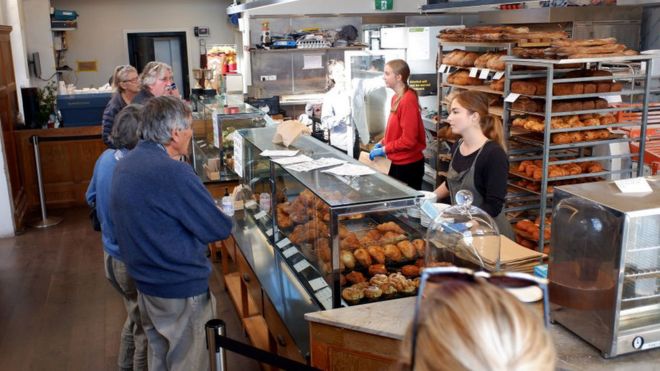 Кафе и пекарня Daily Bread в Пт Чев приветствует клиентов, соблюдая меры социального дистанцирования и гигиены 16 мая 2020 года в Окленде, Новая Зеландия