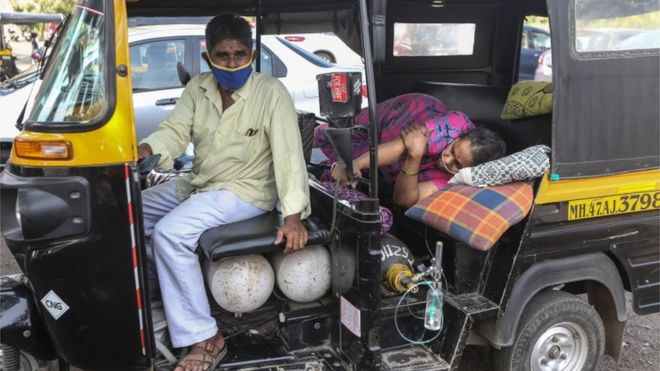 Un mujer yace en un motocarro esperando asistencia médica
