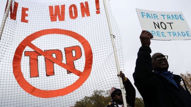 Personas con carteles en contra del TPP.