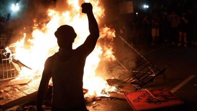 A protesters stands by a fire near the White House in Washington DC. Photo: 31 May 2020