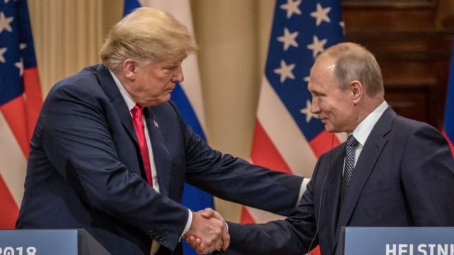 Президент США Дональд Трамп (слева) и президент России Владимир Путин пожимают друг другу руки во время совместной пресс-конференции после саммита