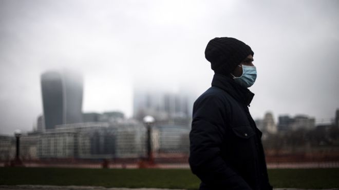 Homem caminha por Londres de máscara