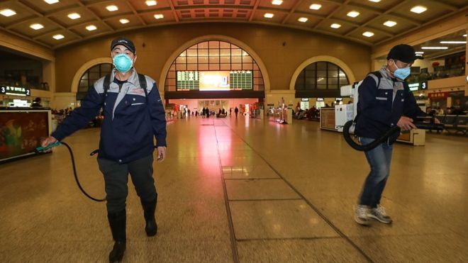 Workers disinfect the Hankou Railway Station in Wuhan, a day before the shutdown