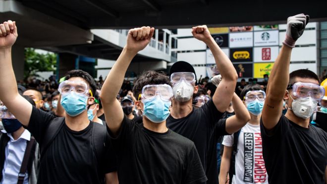 Protesters in masks and goggles chant slogans outside the Legislative Council in Hong Kong on June 12, 2019