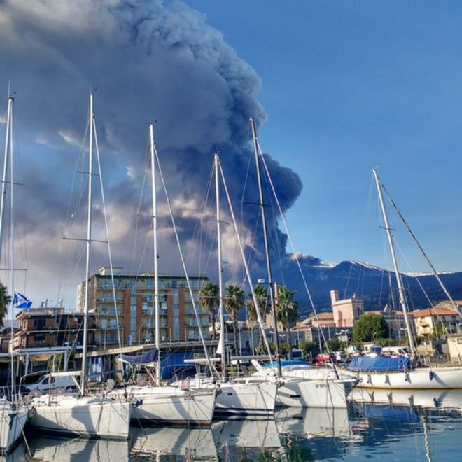 Дым от вулкана с видимыми яхтами