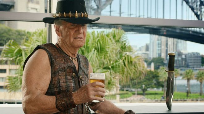 Пол Хоган кратко повторяет свою роль в рекламе, стоя перед мостом через гавань Сиднея