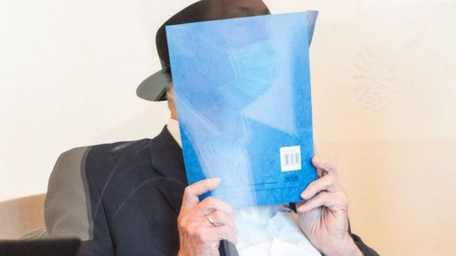 Bruno Dey holds a folder in front of his face in court on 23 July 2020