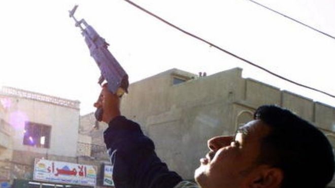 An Iraqi shoots celebratory gunfire in the southern city of Nasiriyah (14 December 2003)