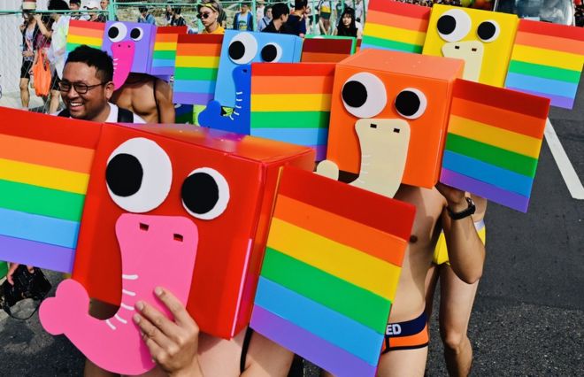 Участники в стилизованных масках радужных слонов принимают участие в ежегодном параде прайдов в Тайбэе