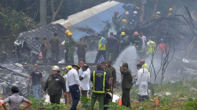 A picture taken at the scene of the accident shows charred portions of the plane and emergency workers