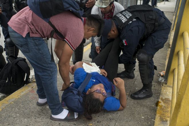 Женщина теряет сознание после нескольких дней ходьбы из Гондураса по переполненному пограничному мосту, разделяющему Гватемалу и Мексику